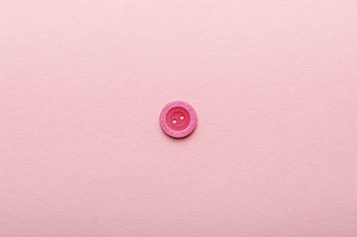 top view of clothing button isolated on pink with copy space