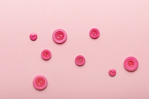 top view of round clothing buttons isolated on pink