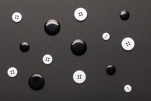 top view of monochrome clothing buttons isolated on black
