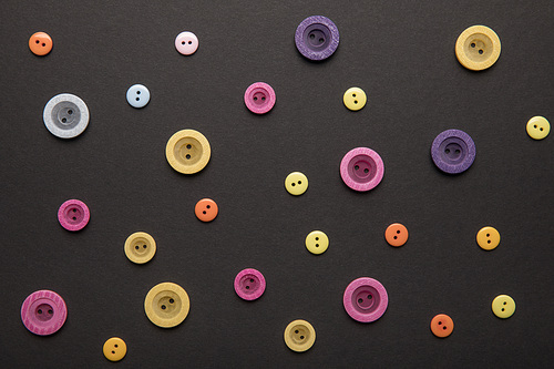 top view of various colorful clothing buttons isolated on black