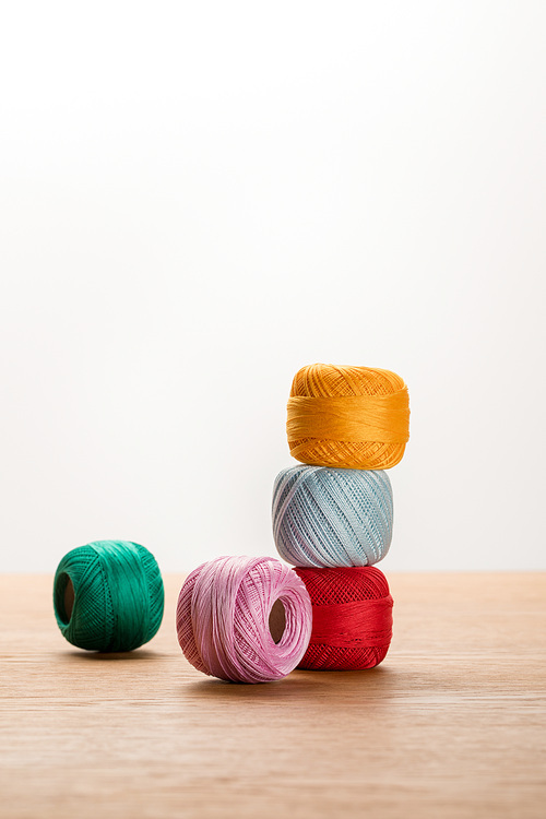 colorful knitting yarn balls on wooden table isolated on white with copy space