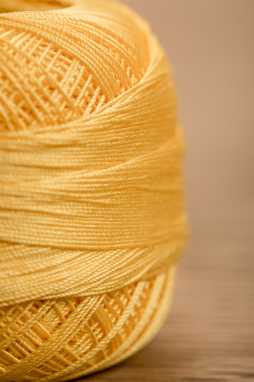 close up view of yellow cotton knitting yarn ball