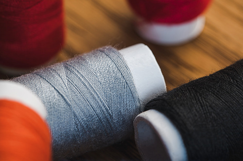 close up view of grey and black cotton thread coils