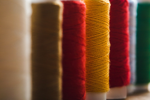 close up view of colorful cotton thread coils in row