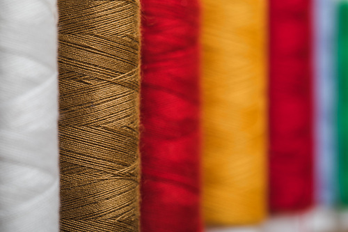 selective focus of colorful cotton thread coils in row with copy space