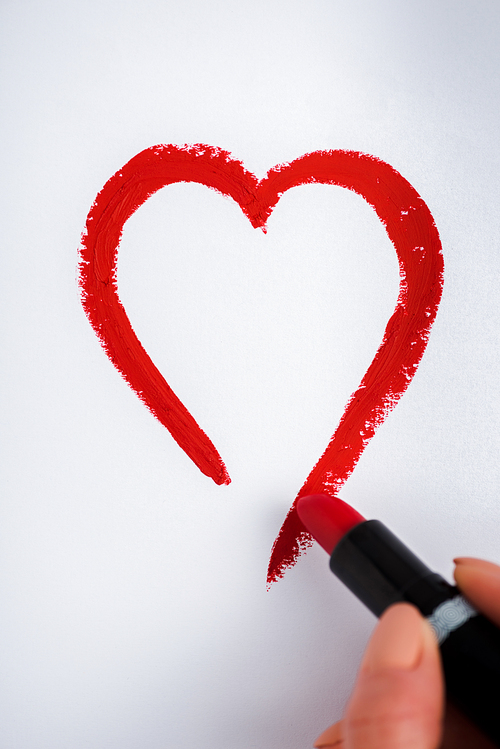 cropped view of woman drawing heart with red lipstick isolated on white
