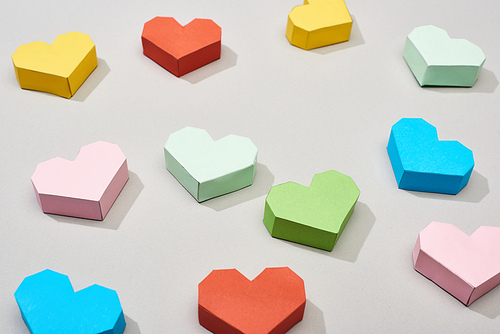 Colorful heart shaped papers on grey background