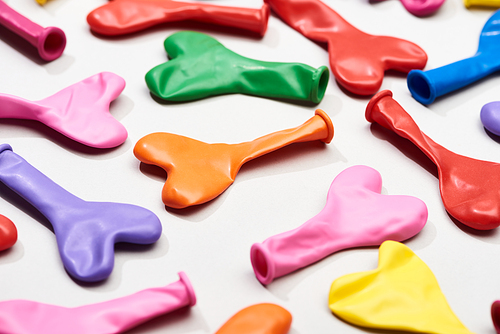 Selective focus of balloons in heart shape on grey background