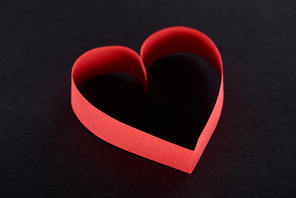 Red paper in heart shape isolated on black