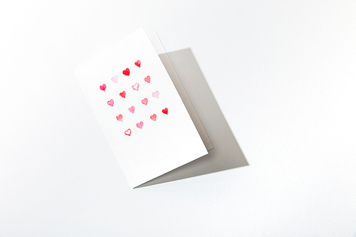 top view of greeting card with hearts on white background