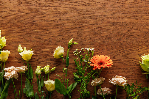 top view of blooming colorful spring flowers on wooden background