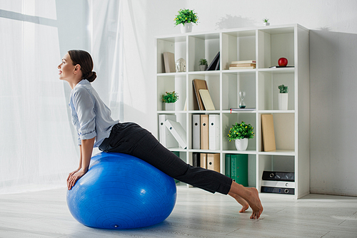 happy businesswoman stretching on fitness balls in office