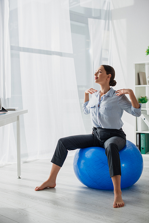 beautiful happy businesswoman exercising on fitness balls in office