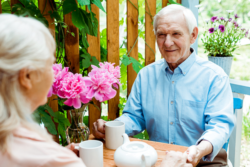 selective focus of happy senior man holding hands with wife