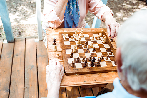 cropped view of retired man and woman playing chess