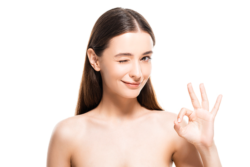 beautiful young naked woman with perfect skin winking and showing okay sign isolated on white