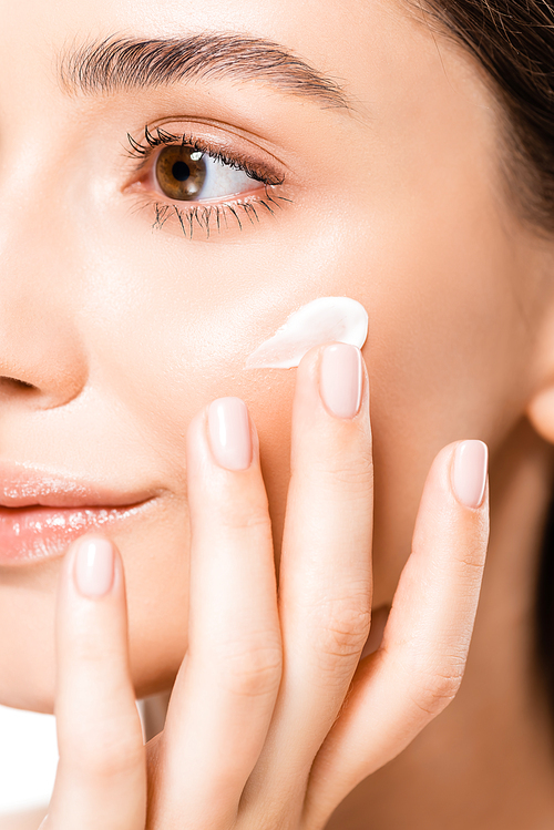 close up view of beautiful young woman with perfect skin applying cosmetic cream on face