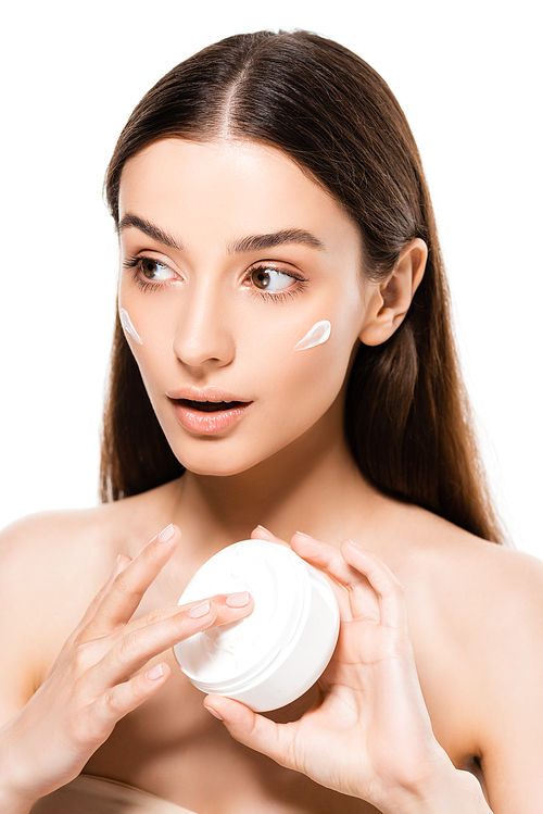 beautiful young surprised woman with perfect skin applying cosmetic cream isolated on white