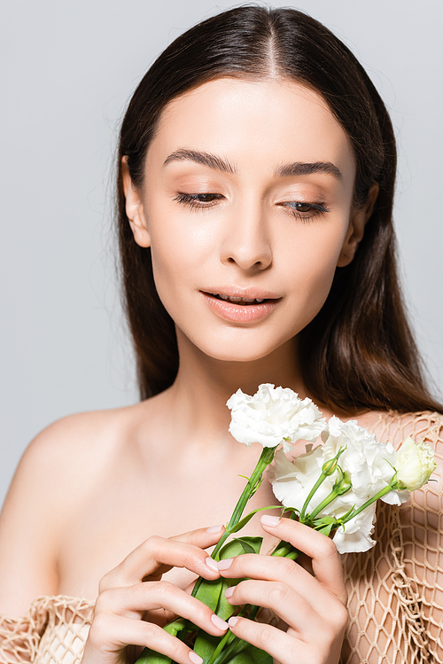 tender beautiful brunette woman with white carnations isolated on grey