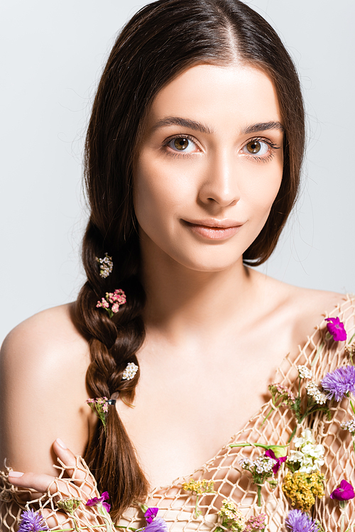 beautiful woman with braid in mesh with spring wildflowers  isolated on grey