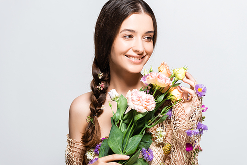 smiling beautiful woman with braid in mesh with spring wildflowers isolated on grey