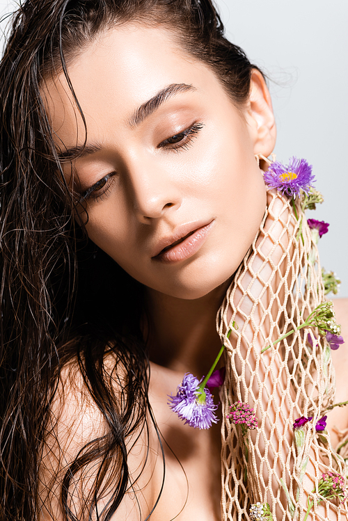 beautiful woman with wet hair in mesh with purple flowers posing isolated on grey