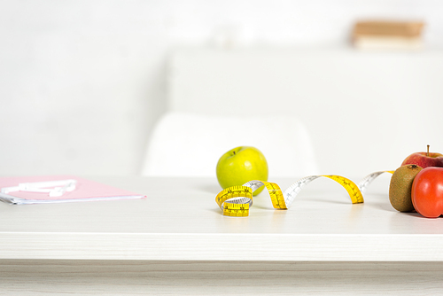 folder, measure tape and fresh food on table