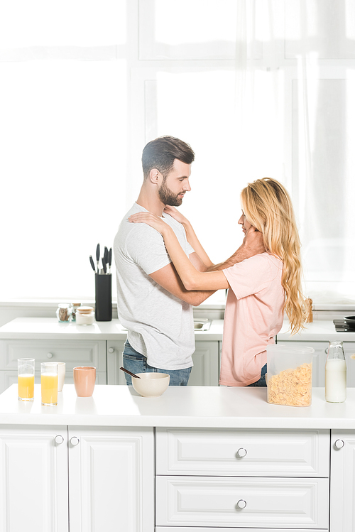couple embracing during breakfast at kitchen in morning