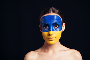 naked young woman with painted Ukrainian flag on skin  isolated on black
