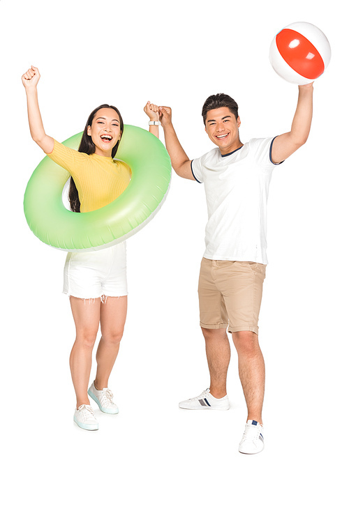 happy asian couple with beach ball and swim ring while showing yes gestures on white background