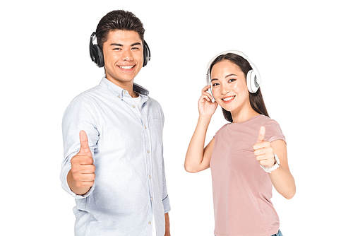 smiling asian man and woman showing thumbs up while listening music in headphone and  isolated on white