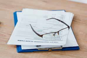selective focus of glasses on clipboard with documents