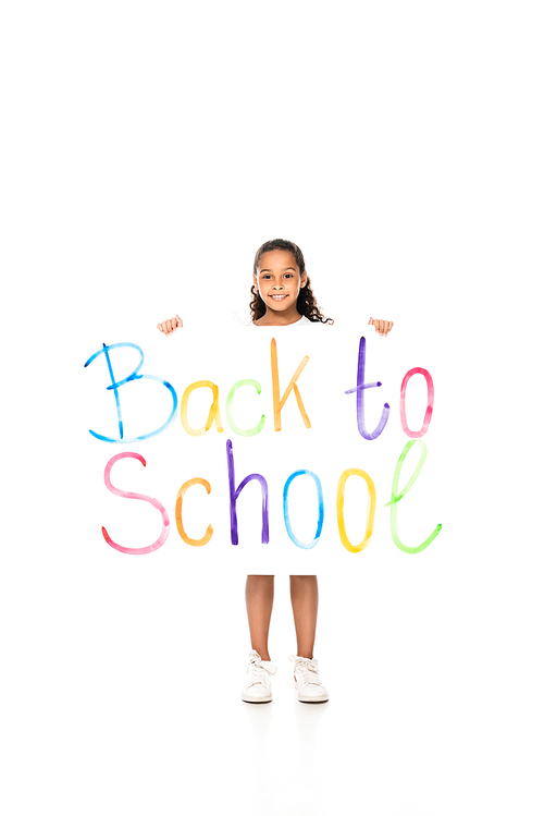 cheerful african american schoolgirl holding placard with back to school inscription on white background