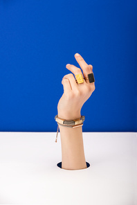 cropped view of woman with bracelet and rings isolated on blue