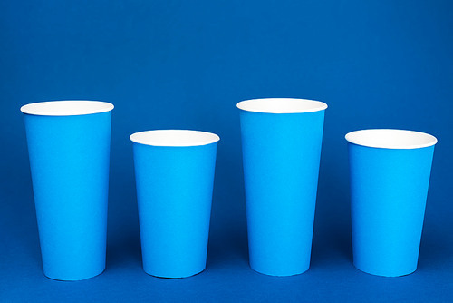colorful paper cups with soda on blue background