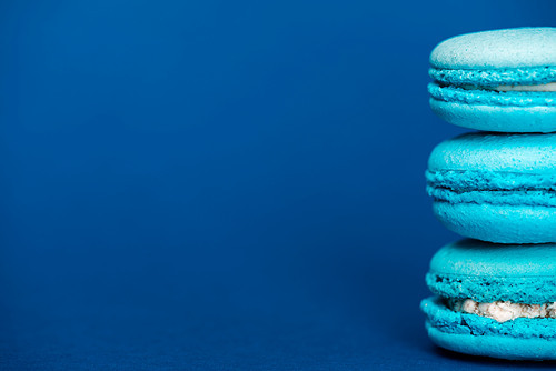 sweet french macaroons on blue background with copy space