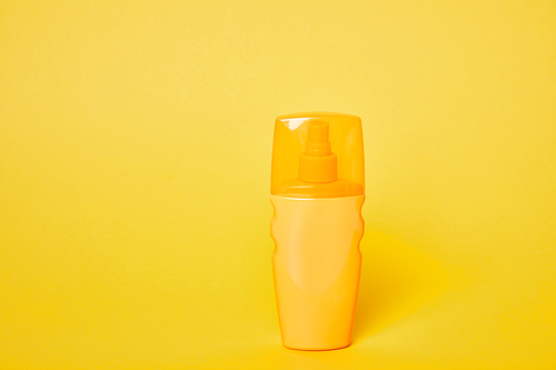sunscreen in yellow bottle on bright yellow background
