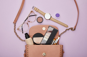 top view of watch near glasses and bag with girls stuff isolated on violet