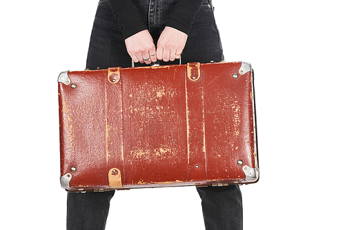 cropped view of girl in jeans holding vintage suitcase isolated on white