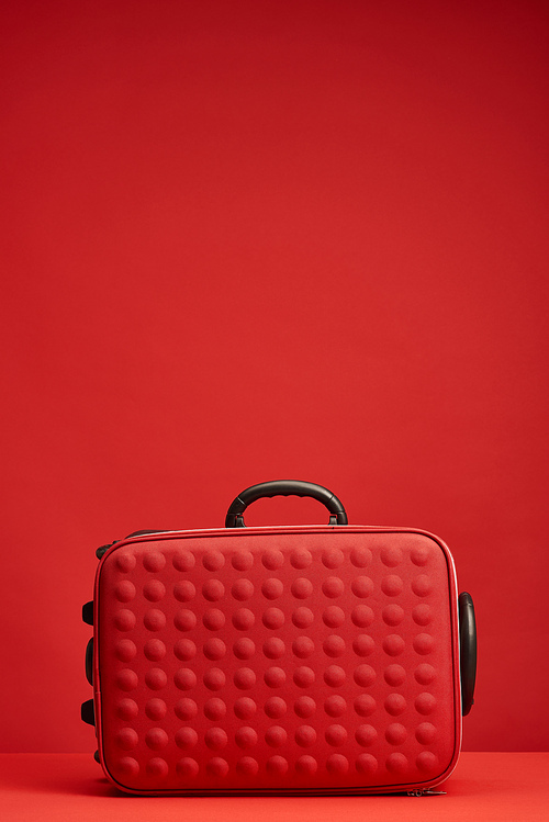 red colorful textured travel bag isolated on red with copy space