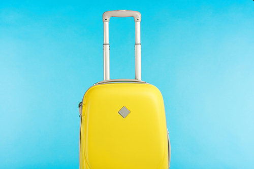 yellow colorful travel bag with handle isolated on blue
