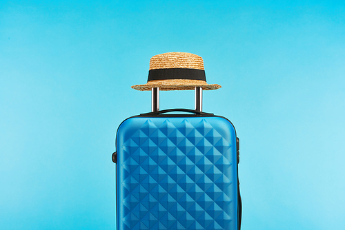 blue colorful travel bag with handle on wheels on blue background