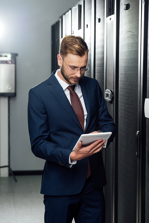 businessman in suit using digital tablet in data center