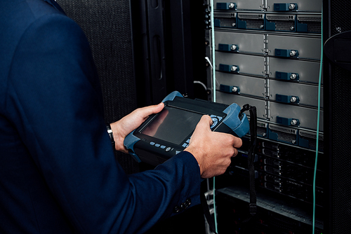 cropped view of man holding reflectometer in server room