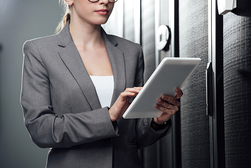 cropped view of businesswoman holding digital tablet in server room