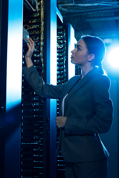 attractive businesswoman looking at server rack in data center