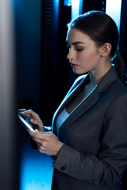 selective focus of businesswoman in formal wear using digital tablet in data center