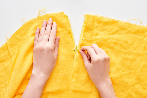 cropped view of woman sewing with needle on white background