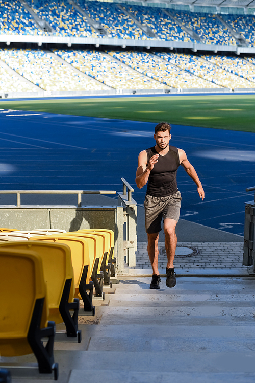 young sportsman running on stairs at stadium