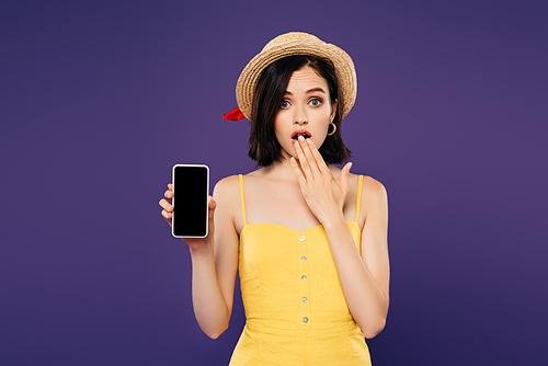 girl in straw hat showing idea gesture and holding smartphone with blank screen isolated on purple